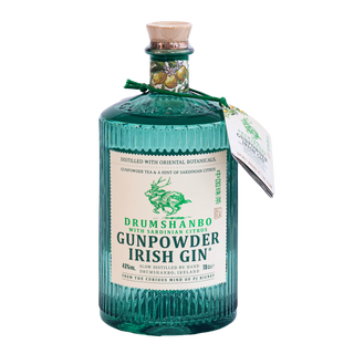 A bottle of Drumshanbo Ginpowder Irish Gin with Sardinian Citrus, in a ribbed teal glass bottle with a cork stopper and a white label, shown against a plain white background.