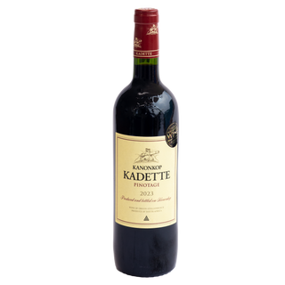 A bottle of Kanonkop Kadette Pinotage 2023 red wine, featuring a cream-colored label with black text and a gold seal, sealed with a dark red capsule, on a solid white background.