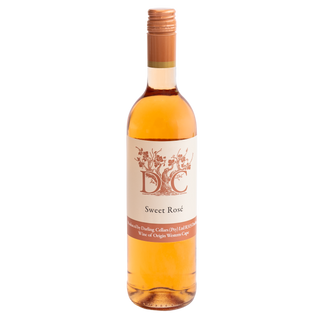 A bottle of D.C. Sweet Rosé white wine by Darling Cellars with a cream label and copper-colored cap, shown against a plain white background.