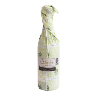 A wine bottle of Life from Stone Sauvignon Blanc by Springfield Estate wrapped in a pale yellow-green patterned paper sleeve with green botanical illustrations and white text..