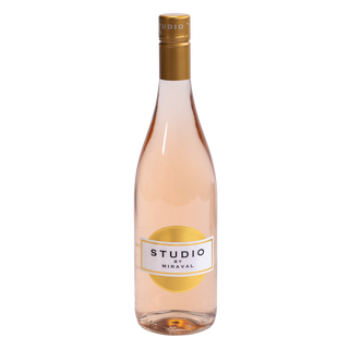 A bottle of Studio by Miraval rosé wine with pale pink liquid, a gold foil cap, and a white and gold label, centered on a plain white background.